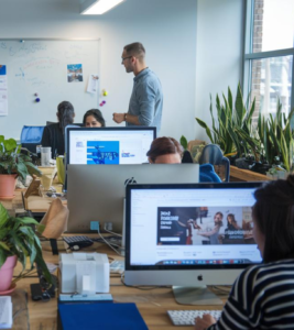 Nuevos Leaders en marketing Equipo de marketing reunido alrededor de una mesa con dispositivos digitales y notas, colaborando en una estrategia.